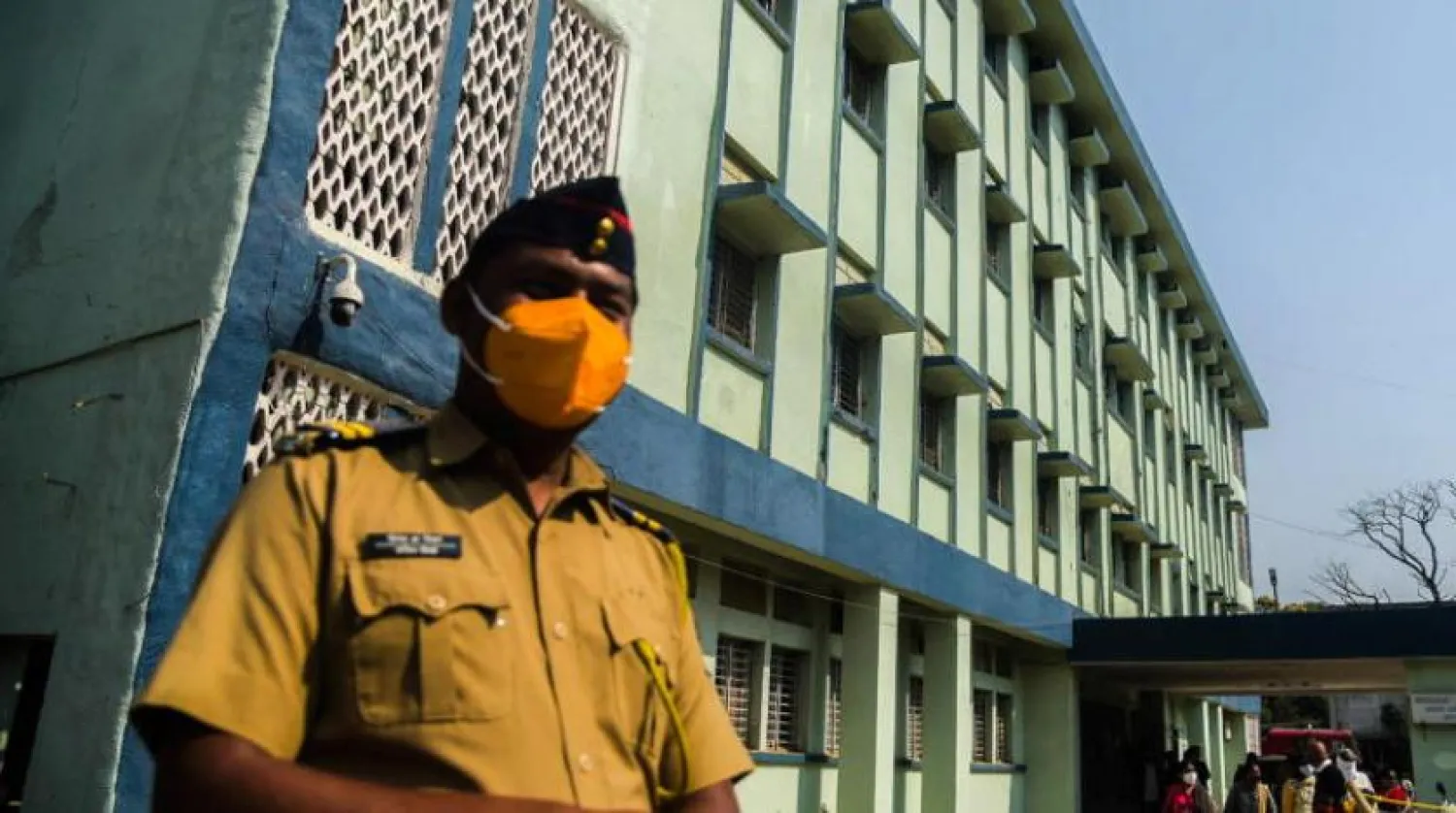 Bir Hintli polis, Maharashtra eyaletinde, yangına maruz kalmış bir doğum hastanesinin önünde duruyor (EPA)
