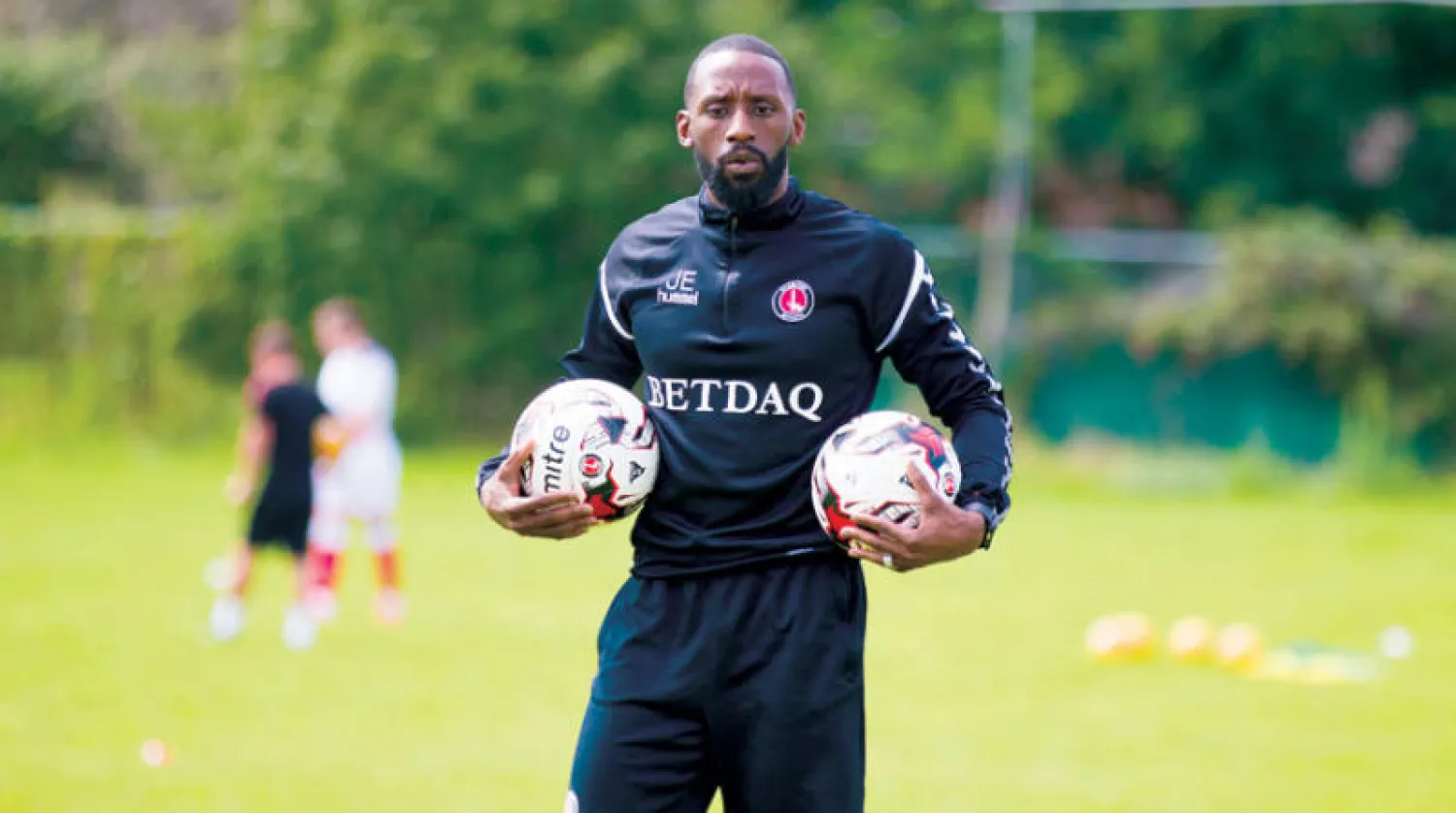 المدير الفني الجامايكي جيسون إيويل يجهز الكرات قبل بدء تدريب لاعبي تشارلتون للشباب