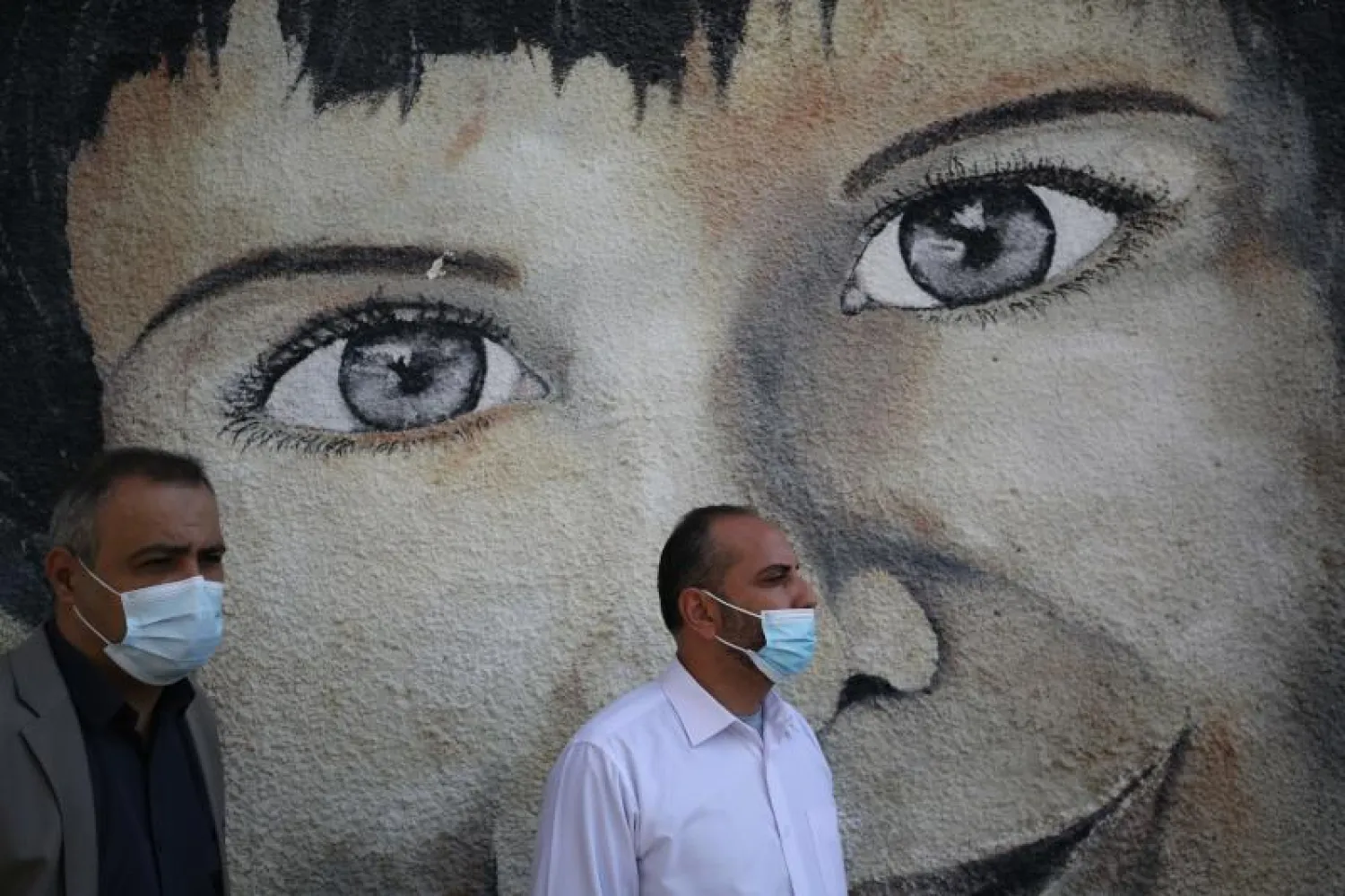 رجلان يضعان كمامتين في غزة (أ.ف.ب)