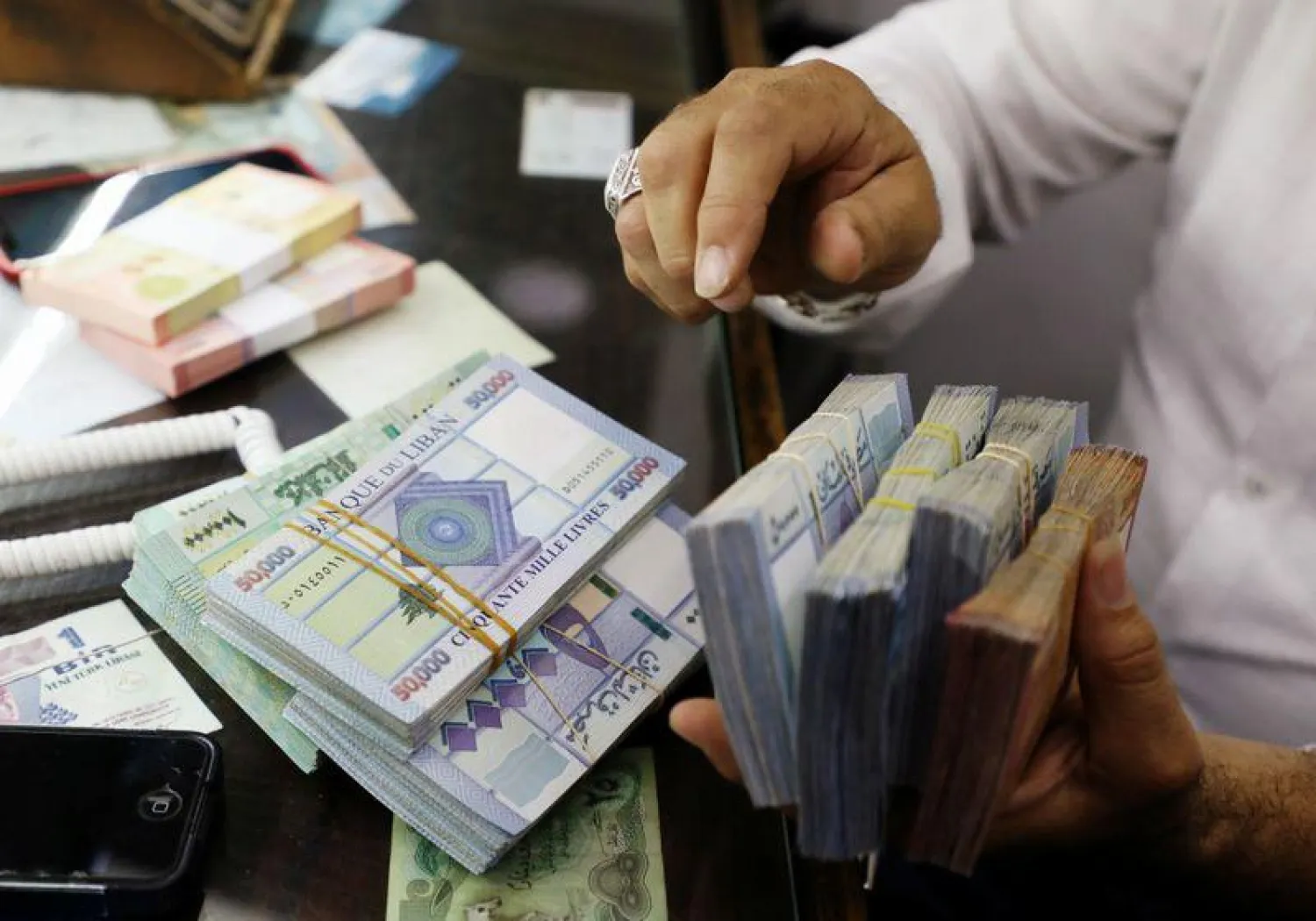 A man counts Lebanese pounds at a currency exchange shop in Beirut, Lebanon October 1, 2020. REUTERS/Mohamed Azakir

 