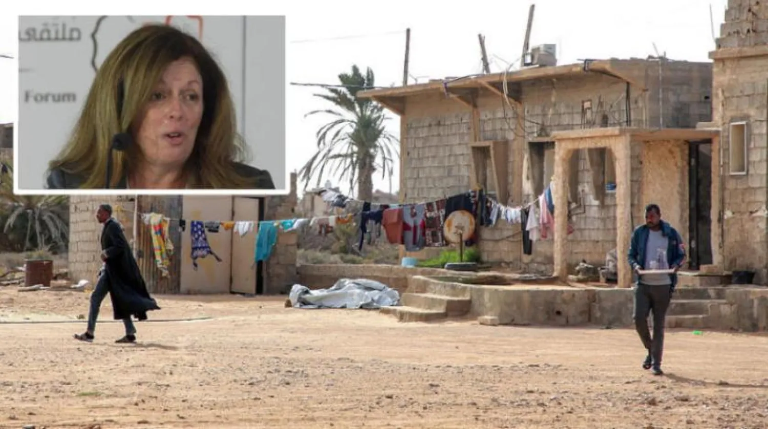 İki Libyalı, Misrata yakınlarındaki Tavurga bölgesinde asılmış çamaşırların yanında yürüyor. Sol üst çerçevede Stephanie Williams görünüyor (AFP)