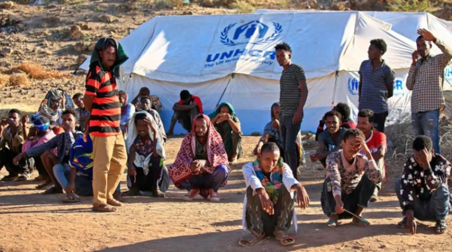 Ethiopian refugees wait outside a UNHCR tent for food at Um Raquba refugee camp in Gedaref, eastern Sudan, on January 7, 2021. (Photo by ASHRAF SHAZLY / AFP)
