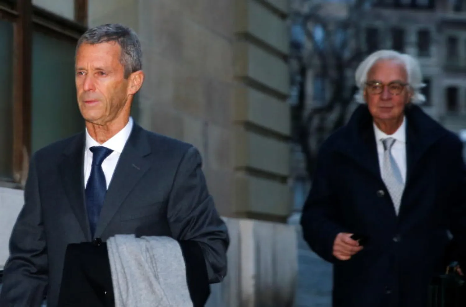 الملياردير الإسرائيلي بيني ستاينمتز والمحامي مارك بونان يصلان إلى قاعة المحكمة للدفاع في جنيف (رويترز)