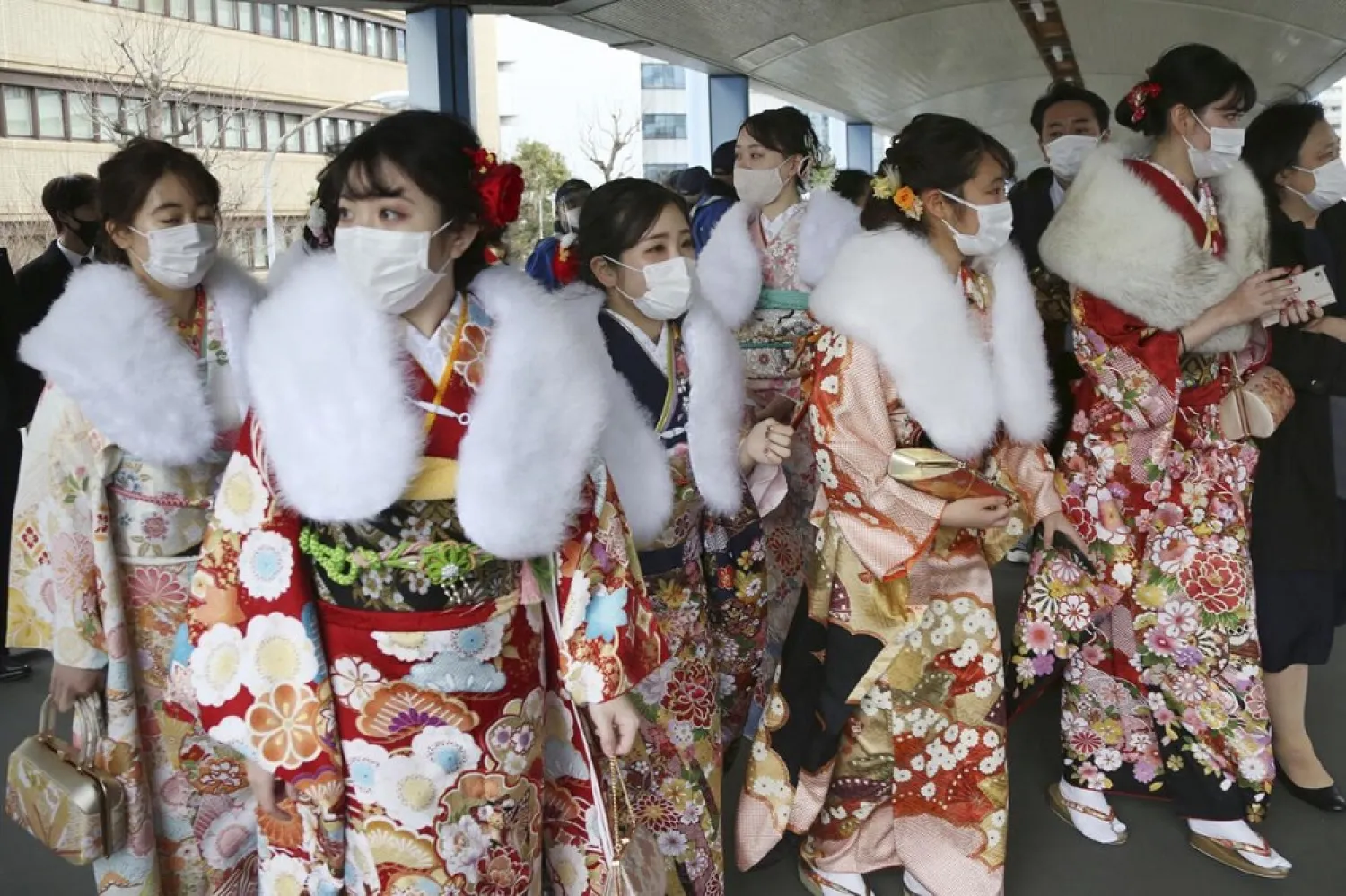 Kimono-clad women wearing face masks to protect against the spread of the coronavirus walk out after a Coming-of-Age ceremony in Yokohama, near Tokyo, Monday, Jan. 11, 2021. (AP)