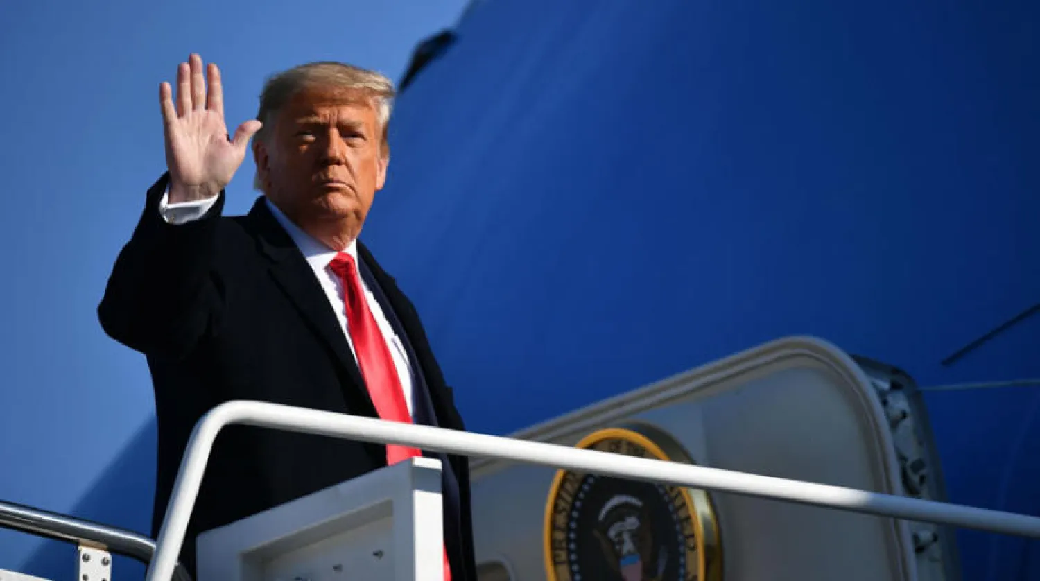 ترمب يحيّي الصحافيين قبل مغادرته قاعدة «أندروز» قرب واشنطن باتجاه تكساس أمس (أ.ف.ب)