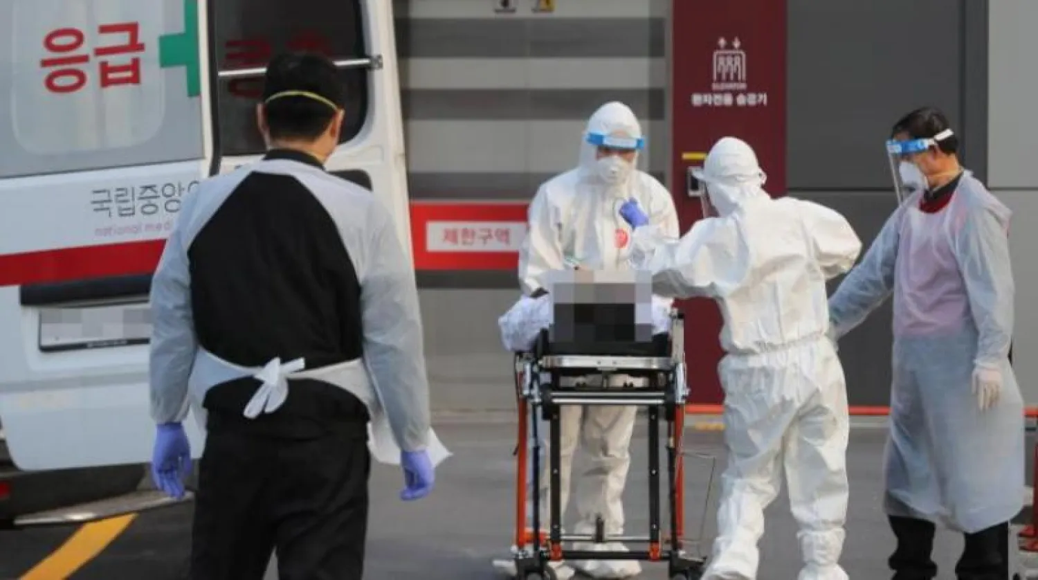 أطباء ينقلون مصاباً بفيروس كورونا إلى مركز طبي في سيول (إ.ب.أ)