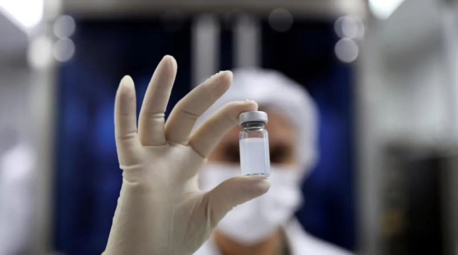 Bir araştırmacının elinde Çin menşeli CoronaVac ilacını tutuyor (Reuters) 
