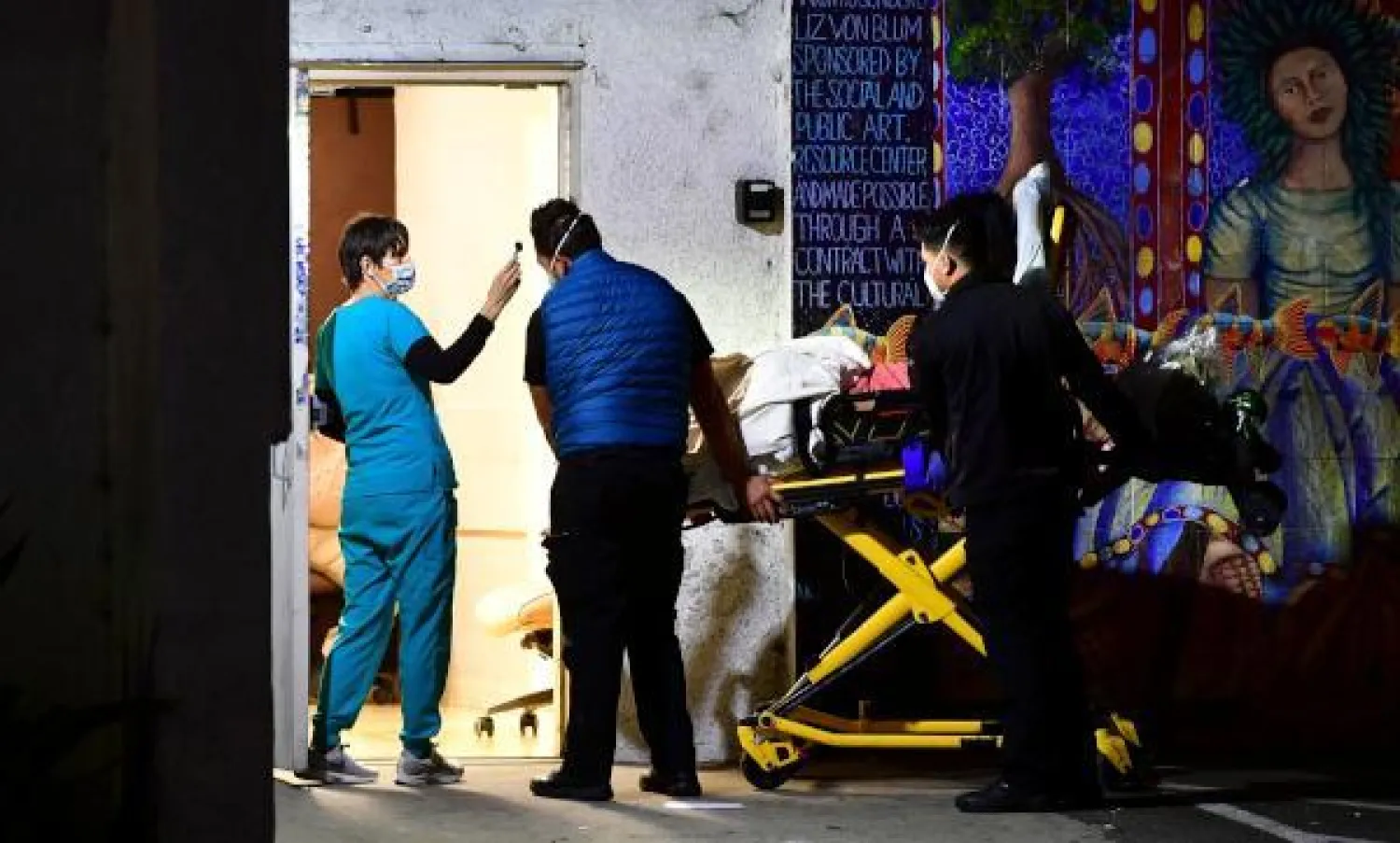 أخصائيو رعاية صحية يخضعون لفحص درجة الحرارة عند وصولهم إلى طوارئ مستشقى في لوس أنجليس (ا.ف.ب)