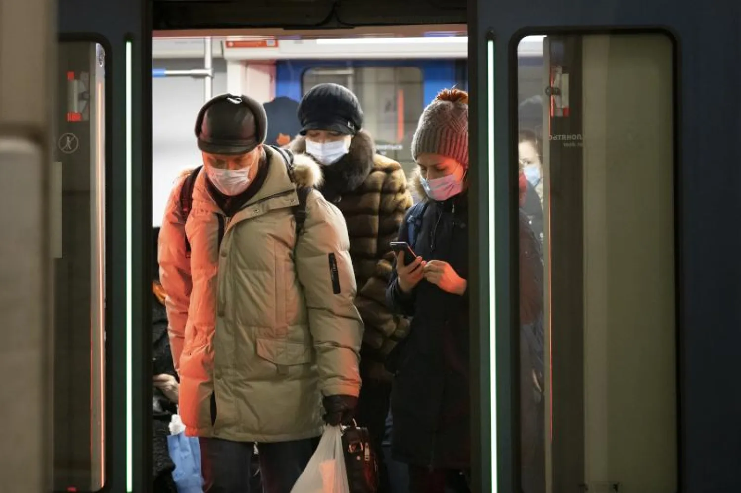 أشخاص يرتدون أقنعة الوجه يخرجون من مترو في موسكو (أ.ب)