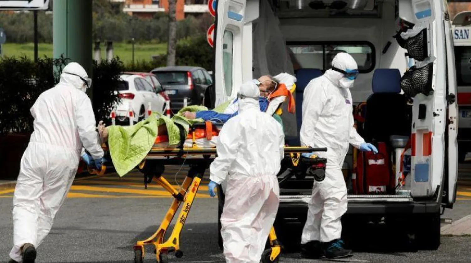 Roma'da koronavirüslü bir hastayı taşıyan sağlık personeli (Arşiv – Reuters)