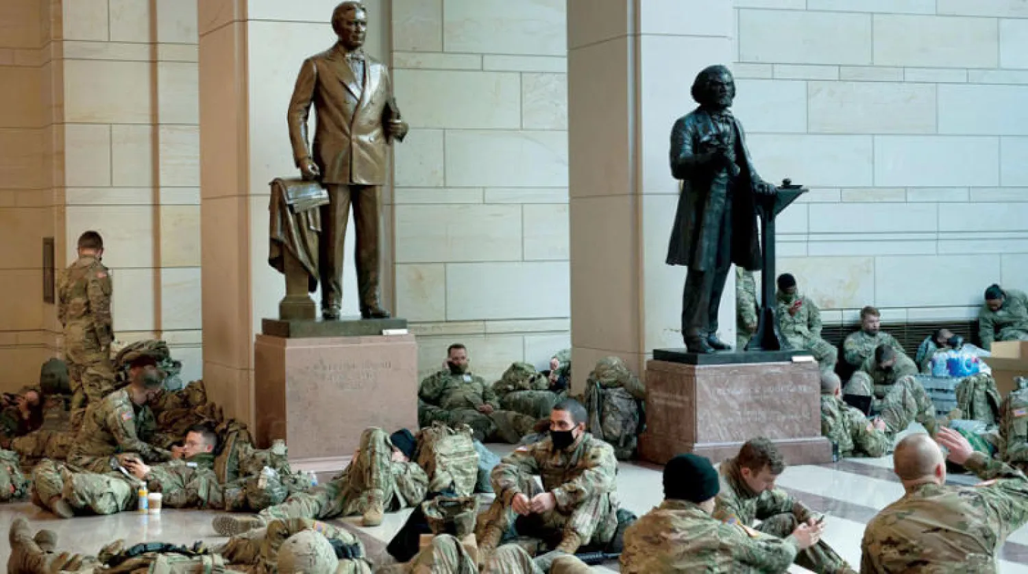 عناصر من الحرس الوطني يأخذون قسطاً من الراحة في أروقة مبنى الكونغرس أمس (أ.ف.ب)