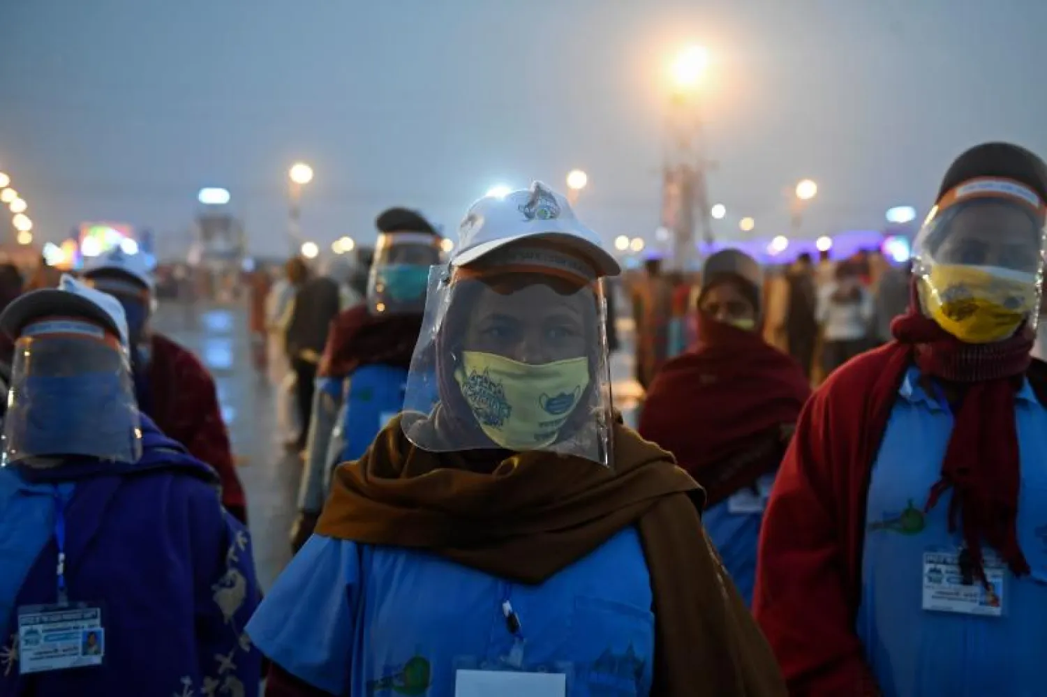 متطوعون يضعون دروعاً للوجه وأقنعة خلال المشاركة بمهرجان في جزيرة ساغار الهندية (أ.ف.ب)