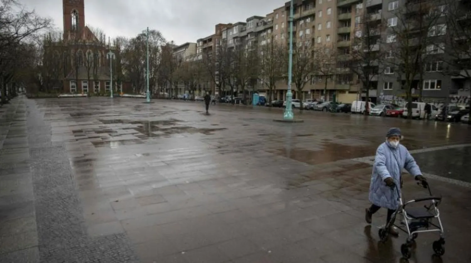 Bir kadın Berlin'in Schoenberg bölgesindeki Winterfieldplatz meydanına doğru ilerliyor (AFP) 

