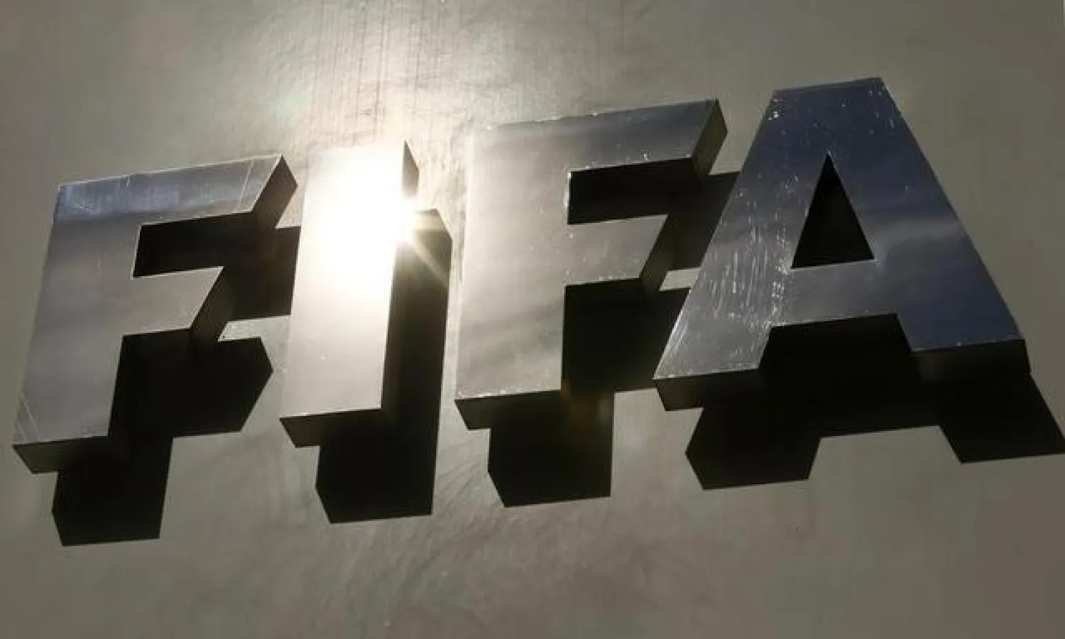 The sun is reflected in FIFA's logo in front of its headquarters in Zurich, Switzerland October 5, 2015. REUTERS/Arnd Wiegmann