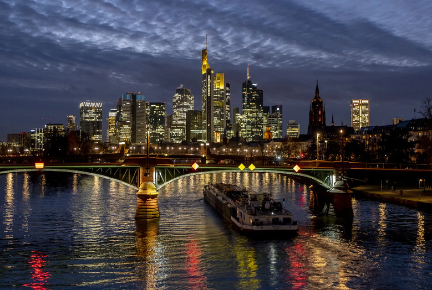 A cargo ship passes under a bridge over the river Main in Frankfurt, Germany, Wednesday, Jan. 13, 2021. (AP Photo/Michael Probst)