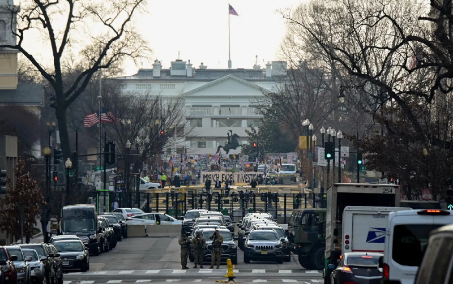 عناصر من الحرس الوطني يقفون أمام أسطول مركبات إنفاذ القانون والسياج الأمني قرب البيت الأبيض في واشنطن (رويترز)