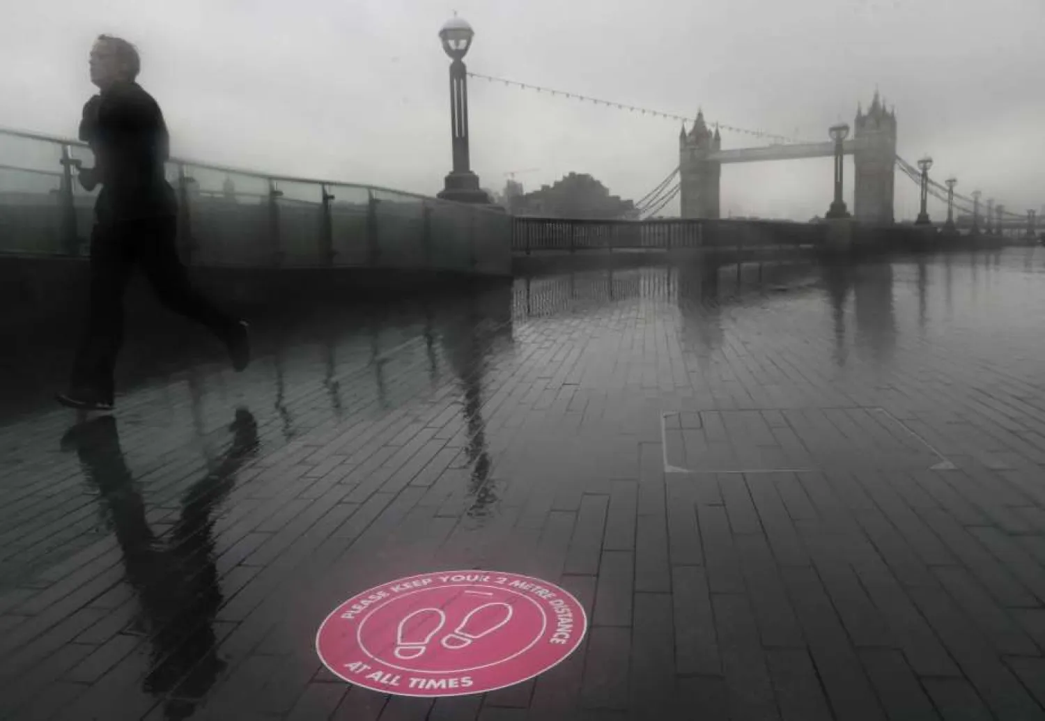 A jogger exercises on the banks of the River Thames with the backdrop of Tower Bridge in London, Thursday, Jan. 14, 2021 during England's third national lockdown to curb the spread of coronavirus. (AP Photo/Kirsty Wigglesworth)