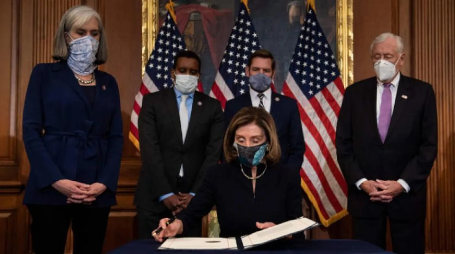 Temsilciler Meclisi Başkanı Nancy Pelosi Trump’ı azletme hükmünü imzalarken (AFP)