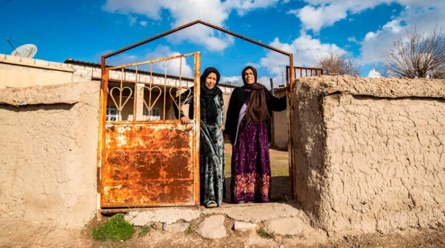 كرديتان تعملان في حياكة السجاد التقليدي أمام مدخل منزلهما في تل عدس بريف الرميلان شمال شرقي سوريا أمس (أ.ف.ب)