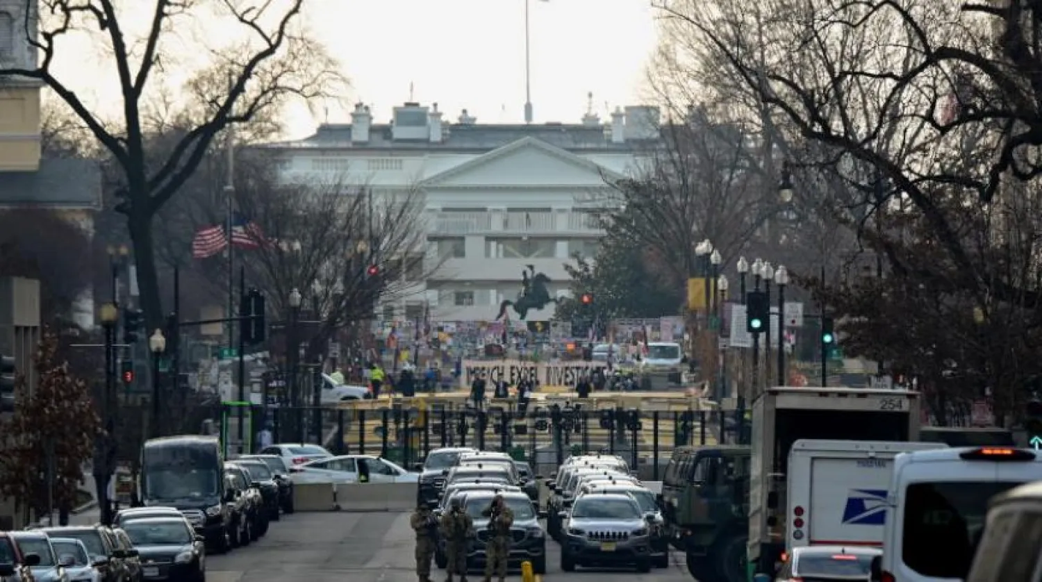 Washington’daki Beyaz Saray yakınlarında Ulusal Muhafızlar, kulluk kuvvetleri araçları ve güvenlik çiti önünde bekliyor (Reuters)