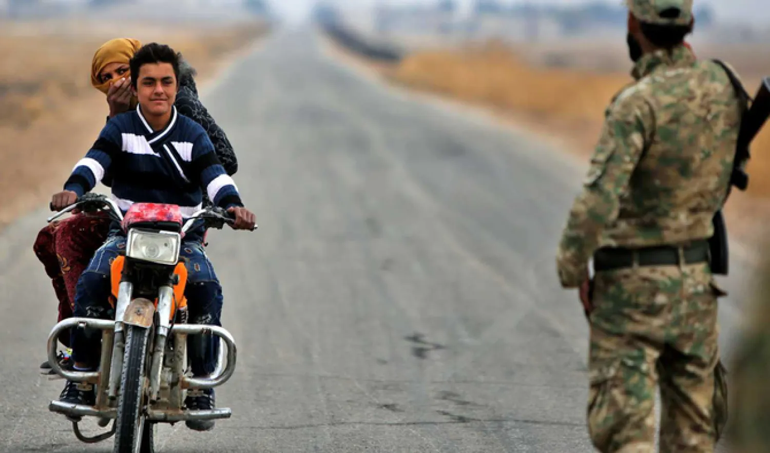 A Syrian fighter mans a security checkpoint before an approaching motorcycle outside Ain Issa in Syria's northern Raqqa province. (File photo: AFP)