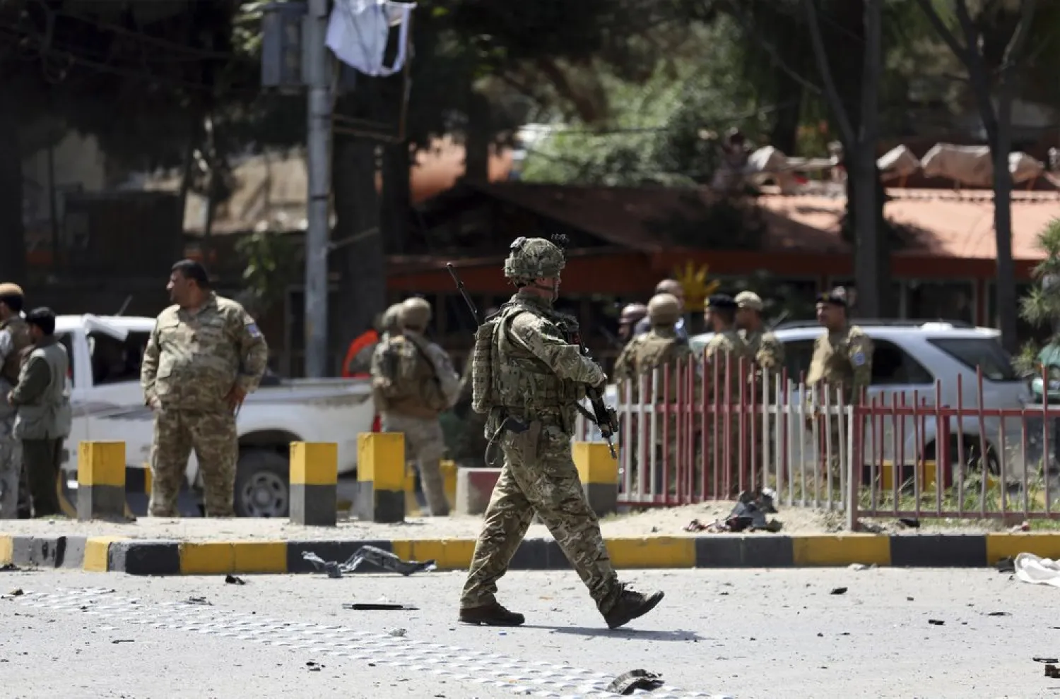FILE: Resolute Support (RS) forces and Afghan security personnel inspect the site of a car bomb explosion in Kabul, Afghanistan, Thursday, Sept. 5, 201. (AP Photo/Rahmat Gul)
