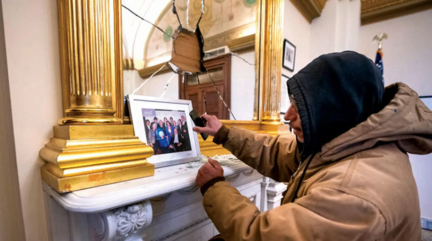 أحد المتظاهرين بعد اقتحامه مكتب بيلوسي في 6 يناير الماضي (إ.ب.أ)