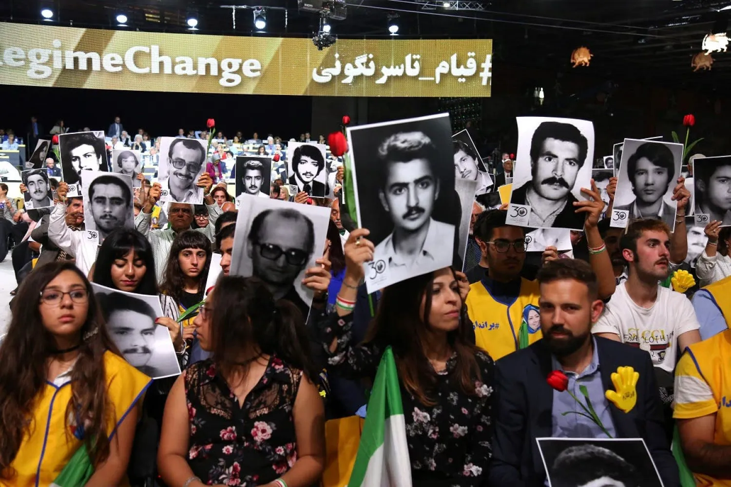 People hold pictures of relatives killed by the Iranian regime, during Free Iran 2018 - the Alternative event on June 30, 2018 in Villepinte. (Reuters)

