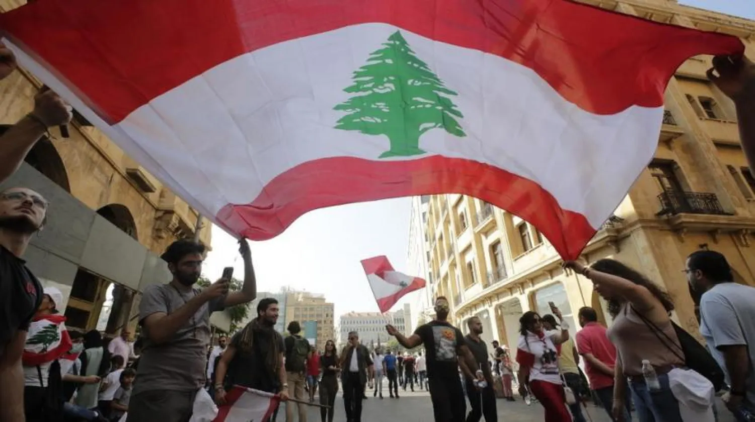 Protesters wave the national flag in downtown Beirut on October 19, 2019. (AFP)
