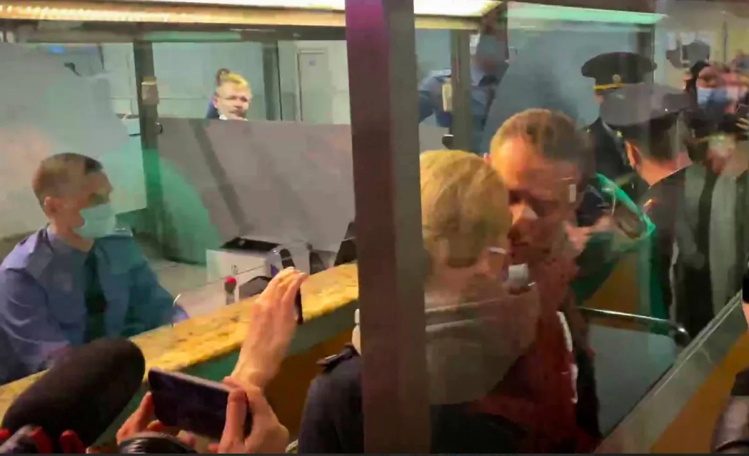 In this photo taken from video, Alexei Navalny kisses his wife Yulia as he is detained by police at the passport control after arriving at Sheremetyevo airport, outside Moscow, Russia, Sunday, Jan. 17, 2021. Russia's prison service says opposition leader Alexei Navalny has been detained at a Moscow airport after returning from Germany. (AP)