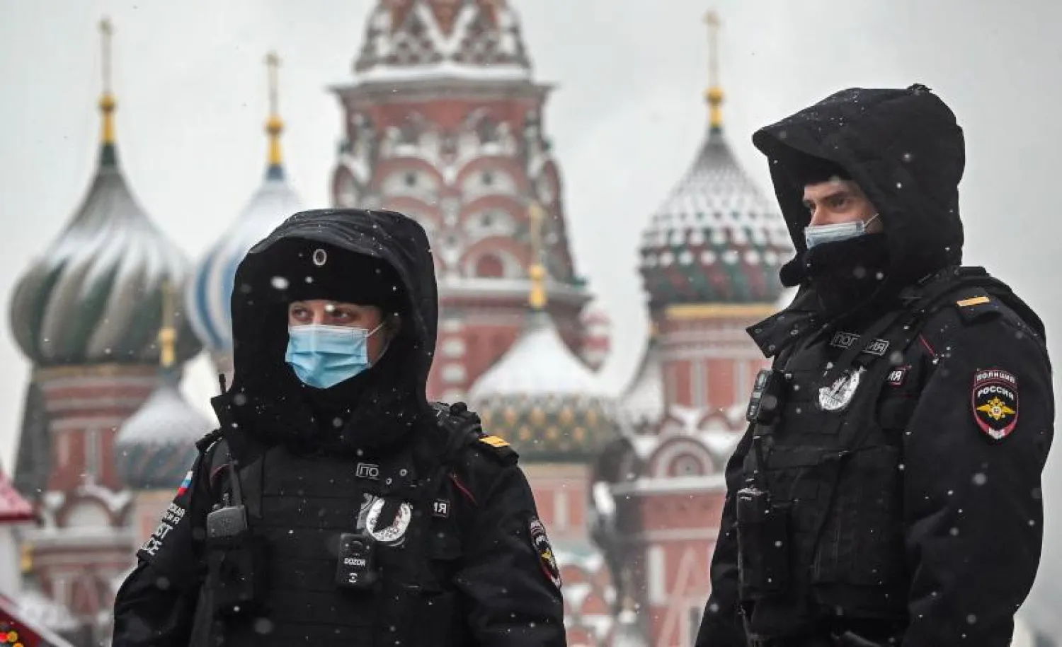 ضباط الشرطة الروسية يرتدون أقنعة الوجه يسيرون على طول الميدان الأحمر أمام كاتدرائية القديس باسيل وسط موسكو (أ.ف.ب)