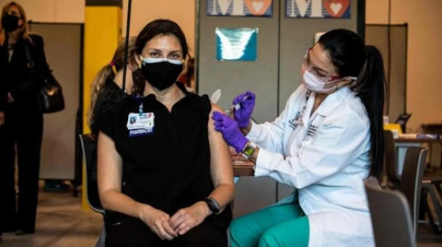 Bir hemşire Florida'da bir sağlık çalışanı Pfizer-Biontech aşısını yapıyor (AFP) 
