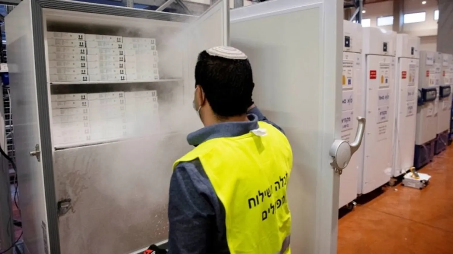An employee opens a freezer containing Pfizer's vaccination against the coronavirus as he works at SLE, a unit of Teva Pharmaceuticals, near Shoham, Israel January 4, 2021. (Reuters)
