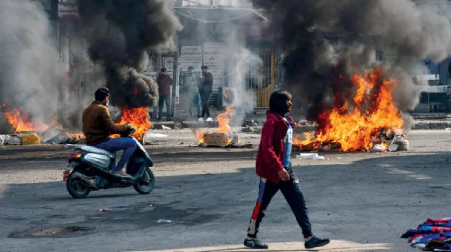 Irak hükümetinin politikalarını protesto eden göstericiler ülkenin güneyindeki Nasıriye şehrinin merkezinde lastik yaktı. (AFP)