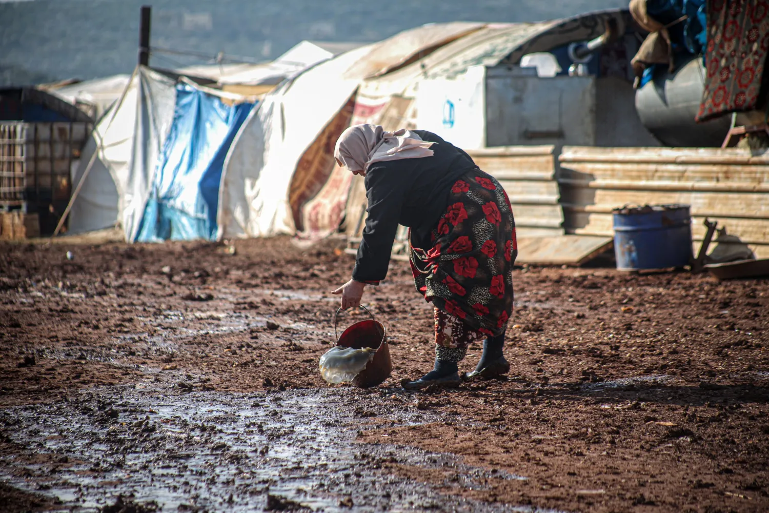 A woman tries to clear her tent of water as heavy rain floods Keferarouk refugee camp in northwestern Idlib, Syria, on Dec.19, 2020. (AA)
