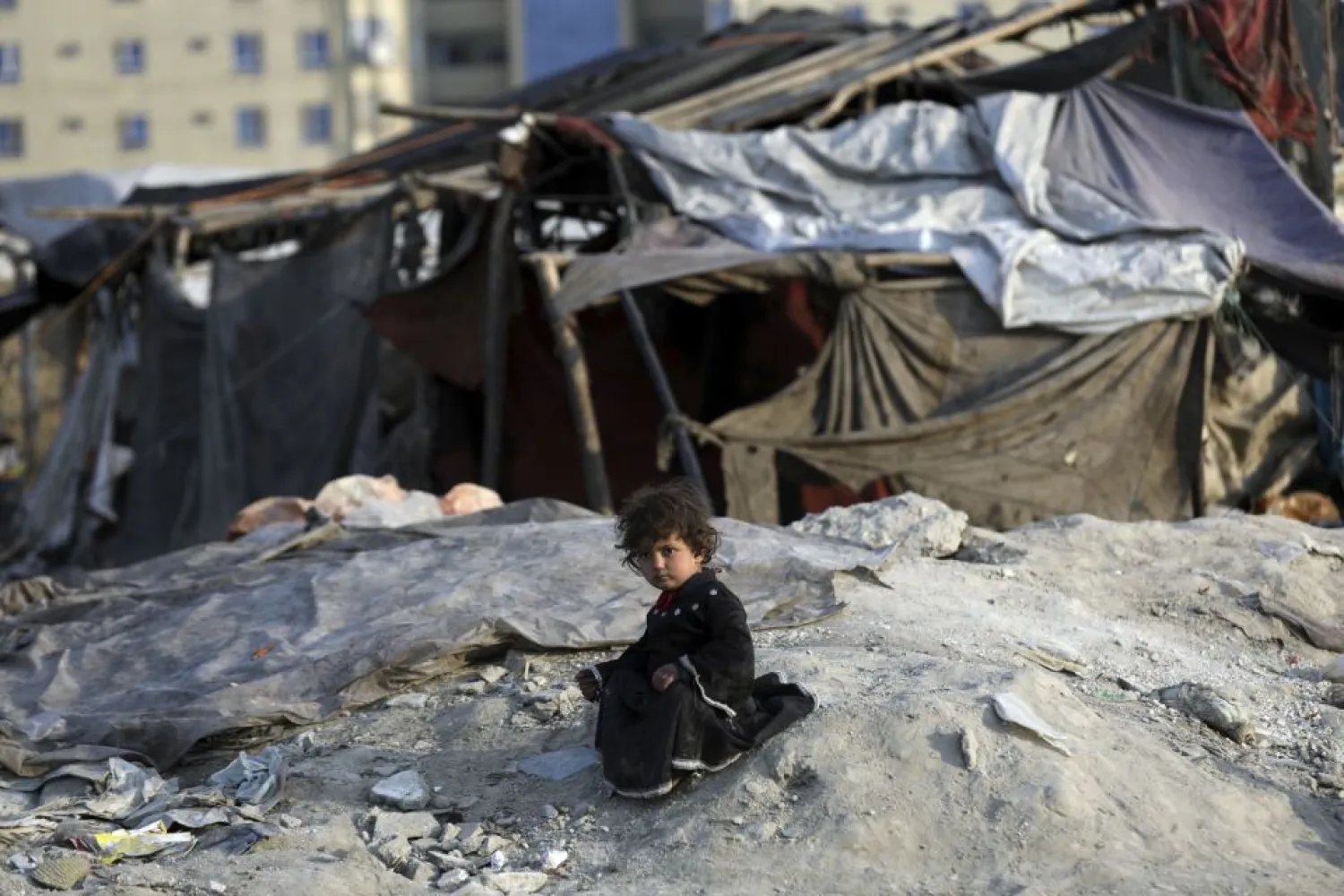 An internally displaced girl poses for photograph outside her temporary home in the city of Kabul, Afghanistan, Monday, Jan. 18, 2021. (AP Photo/Rahmat Gul)