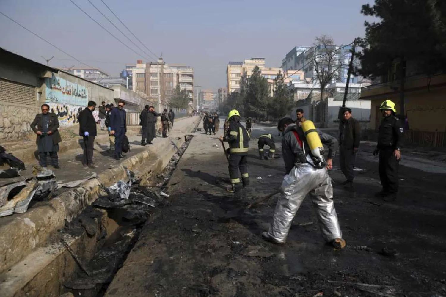 Afghan firefighters work at the site of a bombing attack in Kabul, Afghanistan, Sunday, Jan. 10, 2021. A roadside bomb exploded in Afghanistan's capital Sunday, killing at least a few people in a vehicle, the latest attack to take place even as government negotiators are in Qatar to resume peace talks with the Taliban. (AP Photo/Rahmat Gul)