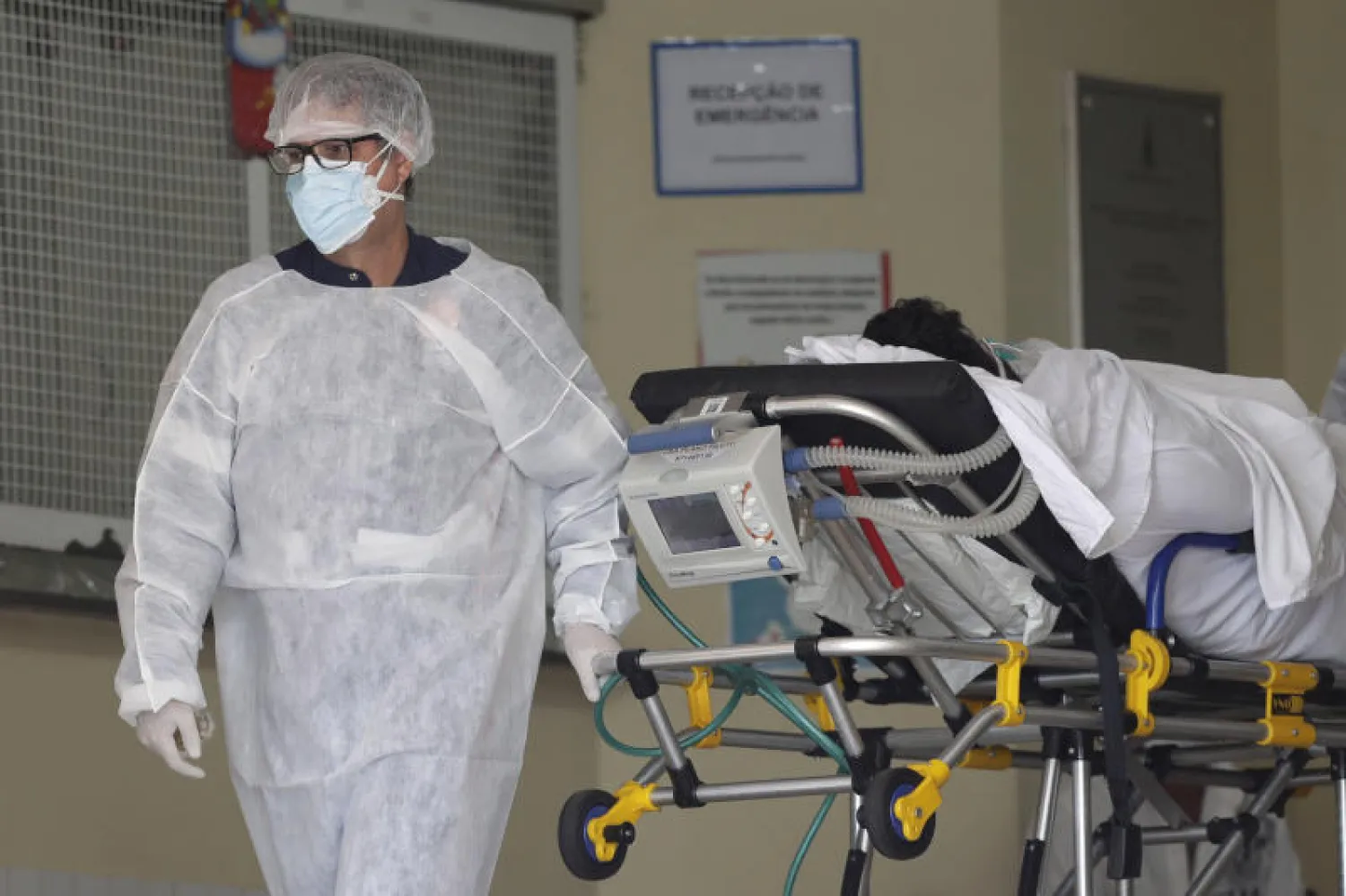ممرض ينقُل مريضاً قد يكون مصاباً بكورونا داخل مستشفى في البرازيل (أ.ب)