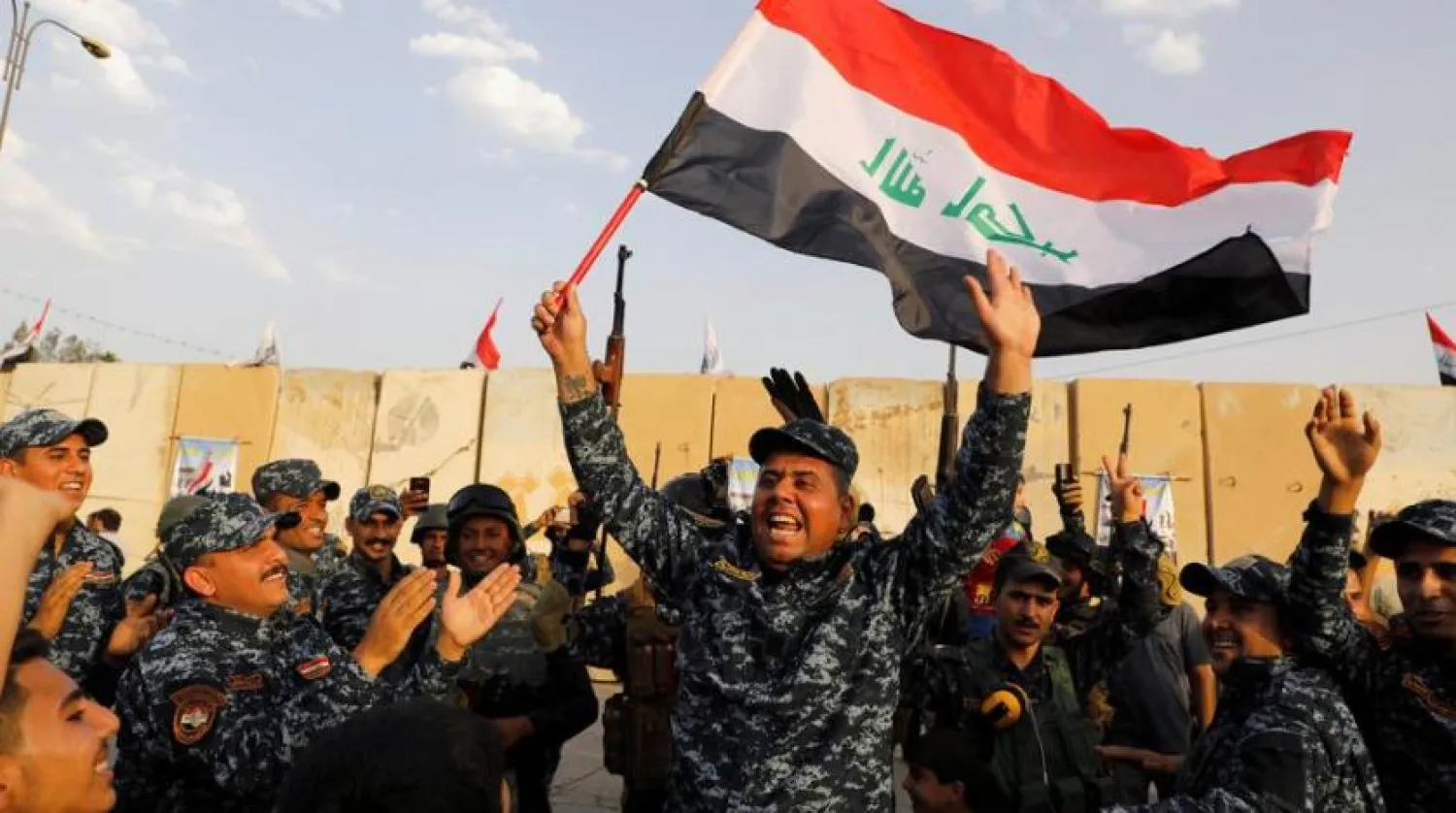 A member of Iraqi Federal Police waves an Iraqi flag as they celebrate victory of military operations against ISIS militants in West Mosul. (Reuters file photo)
