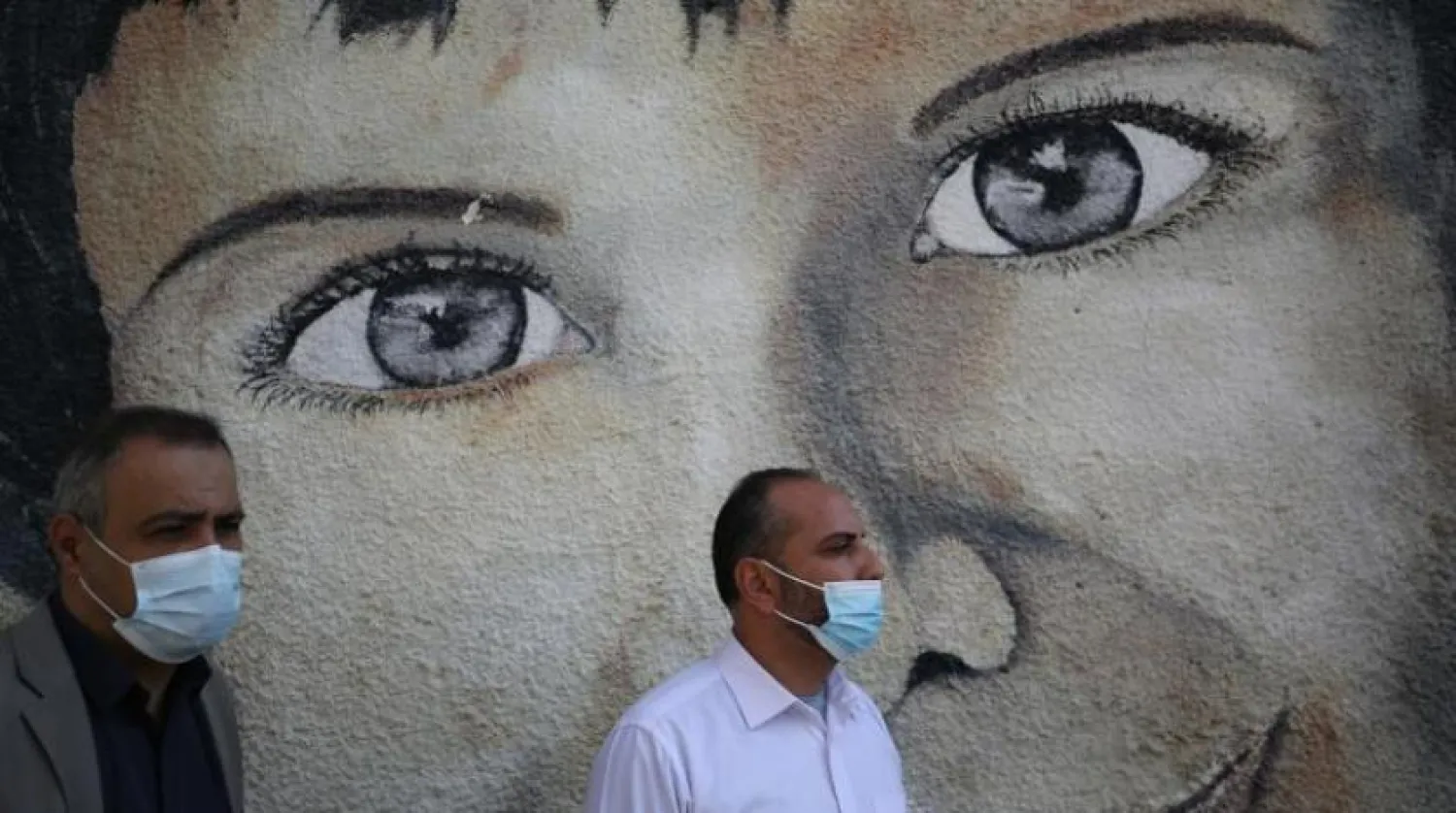 Gazze’de koronavirüsten korunmak için maske takan iki Filistinli (AFP)