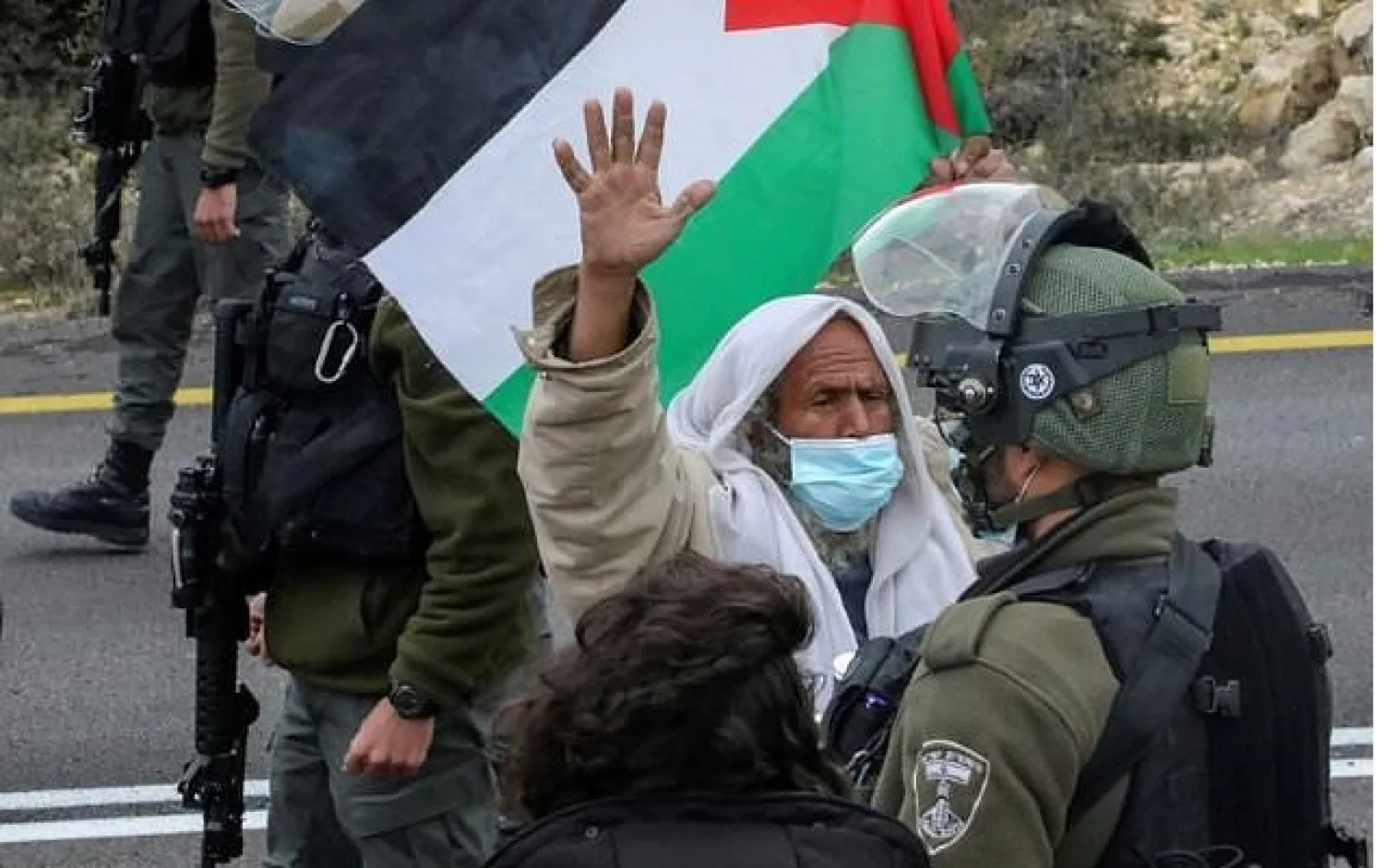 Members of Israeli security forces confront Palestinian and Israeli left-wing protesters demonstrating against settlements and land confiscation, near Yatta village south of Hebron city in the occupied West Bank, on January 15, 2021 - AFP
