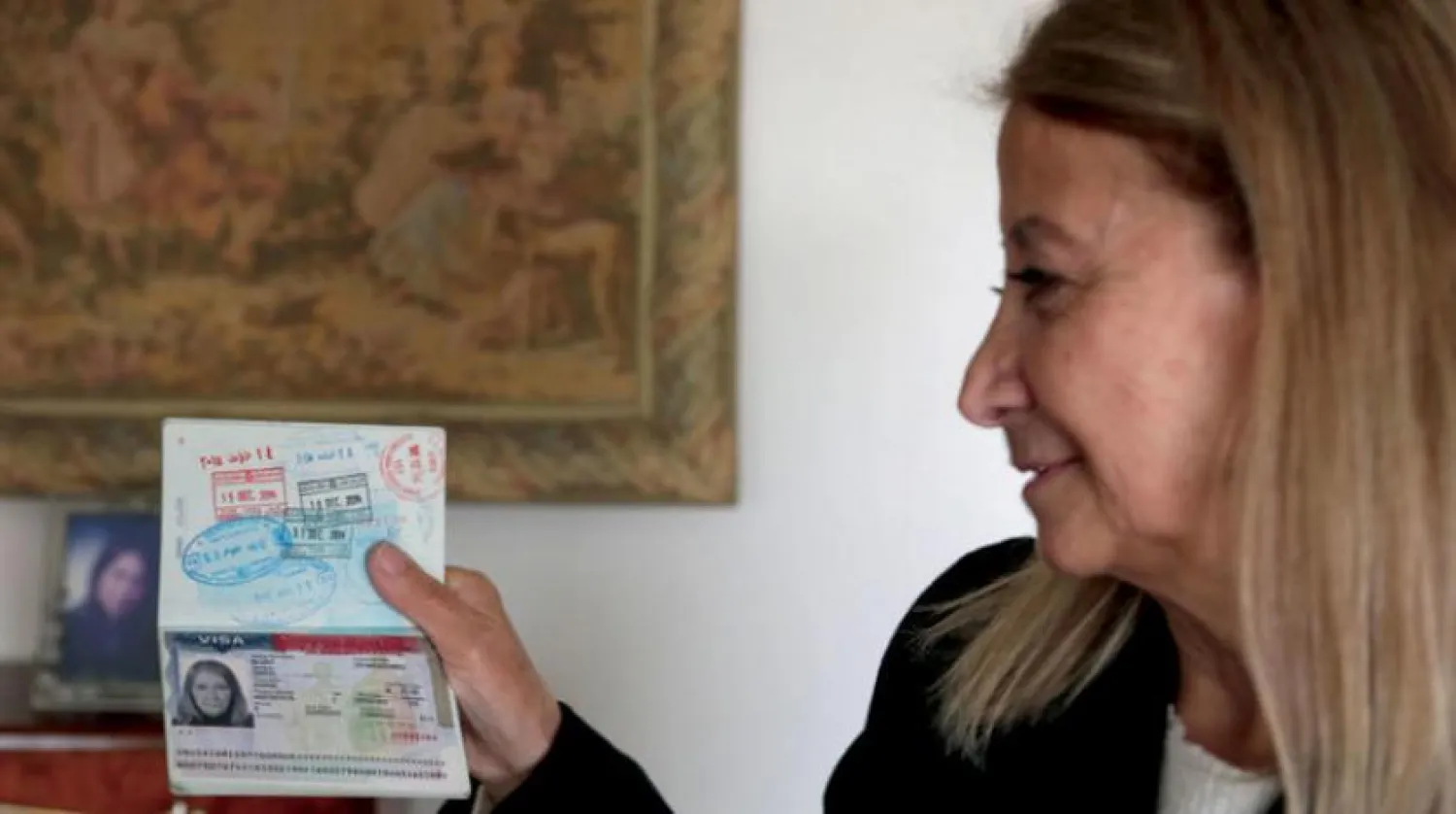 Dahouk Idriss shows a page on her passport during an interview with AFP at her house in the Syrian capital Damascus on January 16, 2021. (Photo by LOUAI BESHARA / AFP)