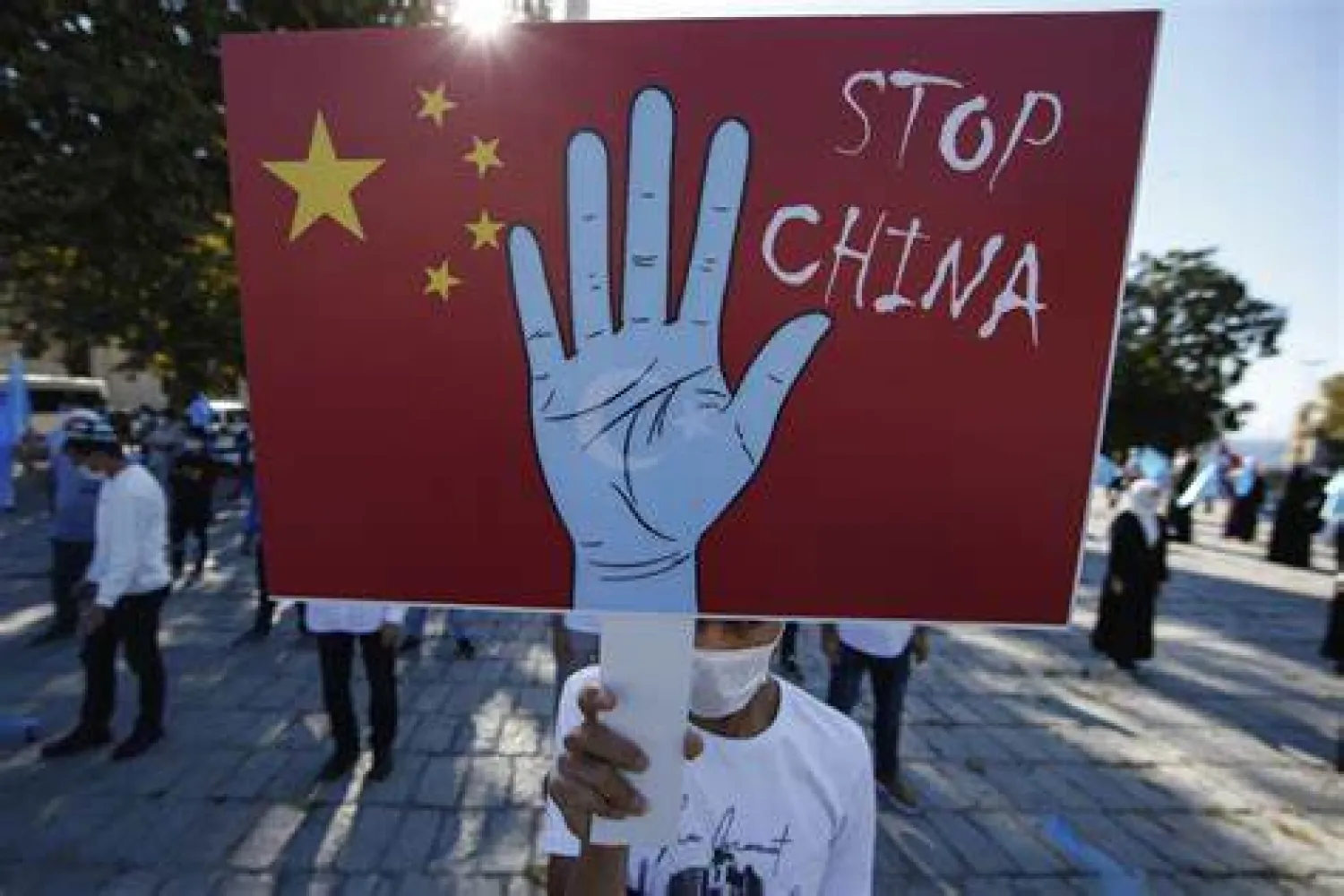 In this file photo taken Thursday, Oct. 1, 2020, a protester from the Uighur community living in Turkey, holds an anti-China placard during a protest in Istanbul, against what they allege is oppression by the Chinese government to Muslim Uighurs in far-western Xinjiang province. (AP Photo/Emrah Gurel, File)