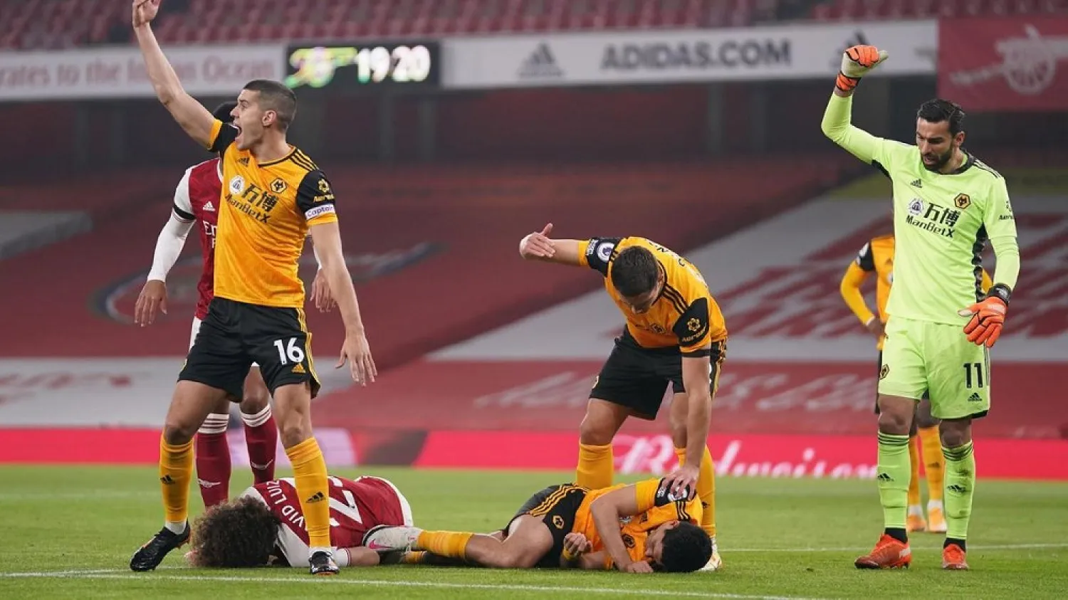 Players gesture for help as David Luiz of Arsenal Wolves' and Raul Jimenez lie stricken on the ground after clashing heads during a Premier League match in November. (EPA)