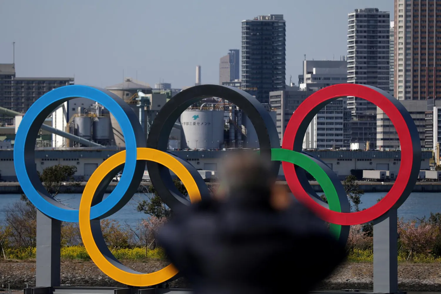 A man takes a picture of the Giant Olympic rings at the waterfront area at Odaiba Marine Park in Tokyo, Japan, March 6, 2020. REUTERS/Stoyan Nenov