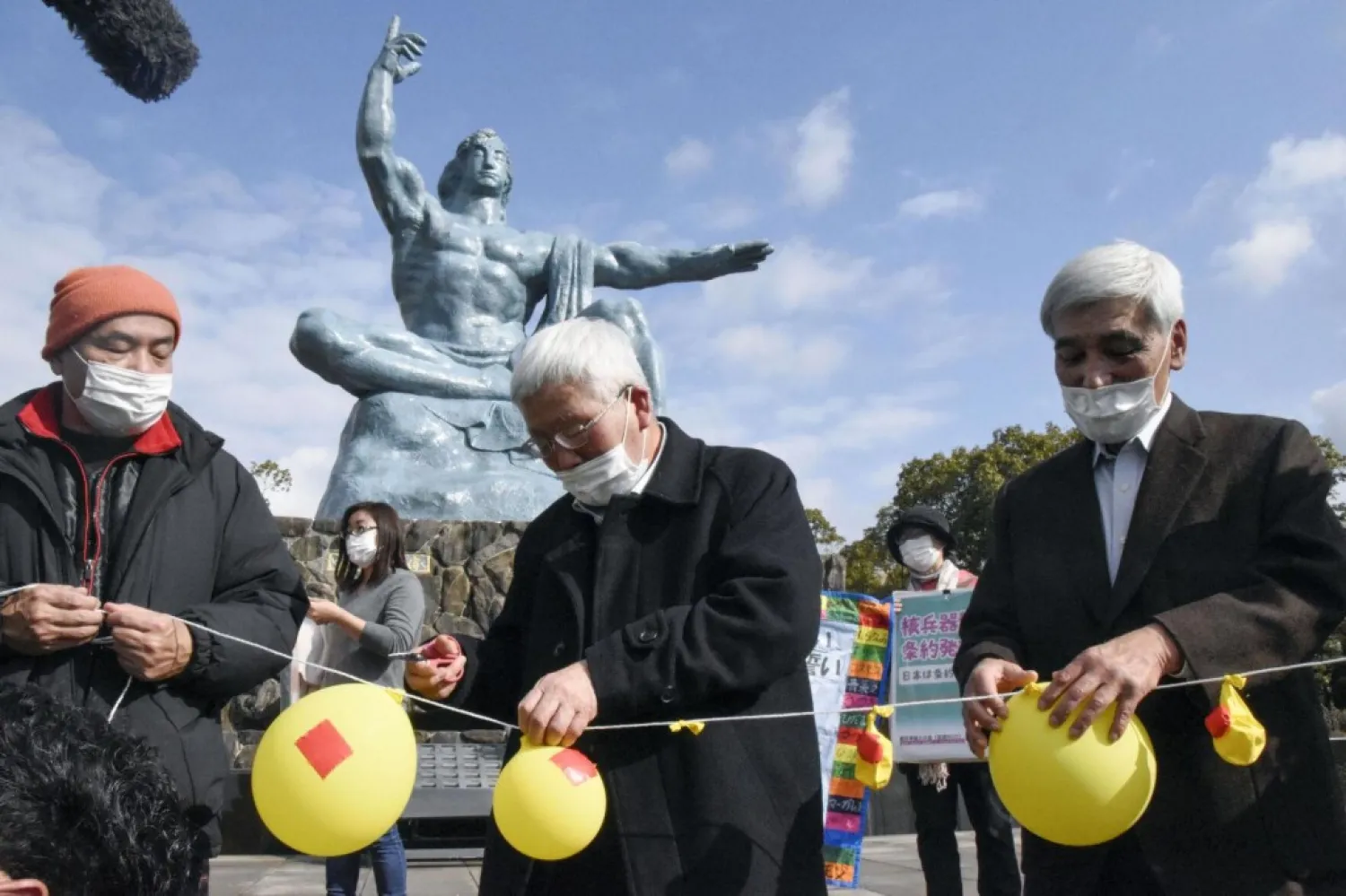 Participants deflate balloons in hope of neutralizing and demolishing nuclear warheads, during a memorial gathering at Peace Park in Nagasaki, southern Japan, Jan. 22, 2021. (AP)
