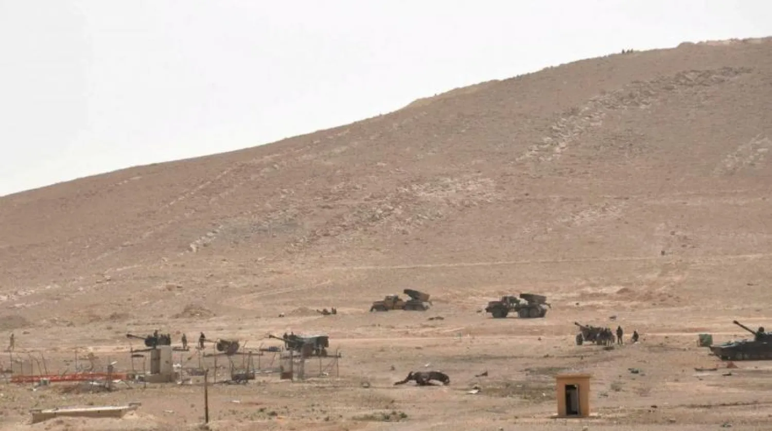 Syrian regime forces stand near their weapons during their offensive to recapture the historic city of Palmyra in 2016. (Reuters)
