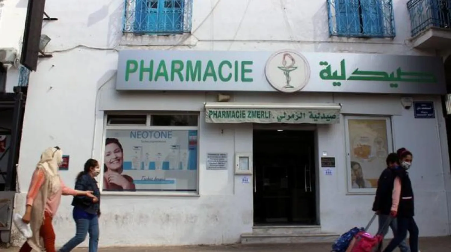 Tunus'ta bir eczanenin önünde koruyucu maske takan vatandaşlar (Arşiv-Reuters)