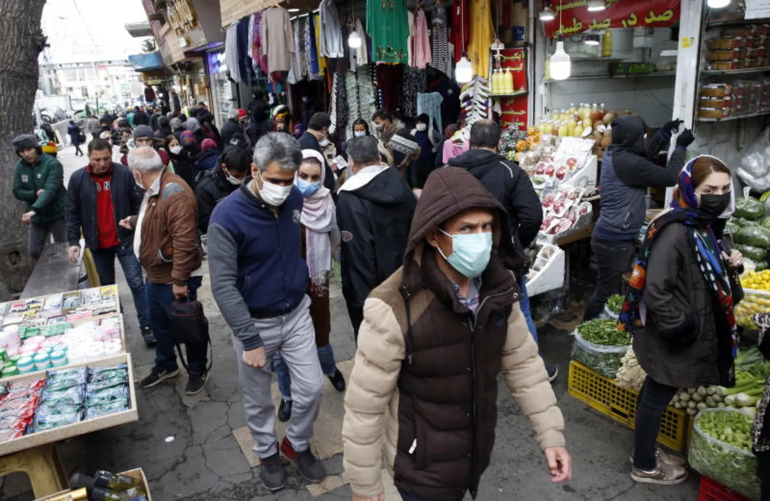 إيرانيون يرتدون أقنعة الوقاية في إحدى أسواق طهران (إ.ب.أ)