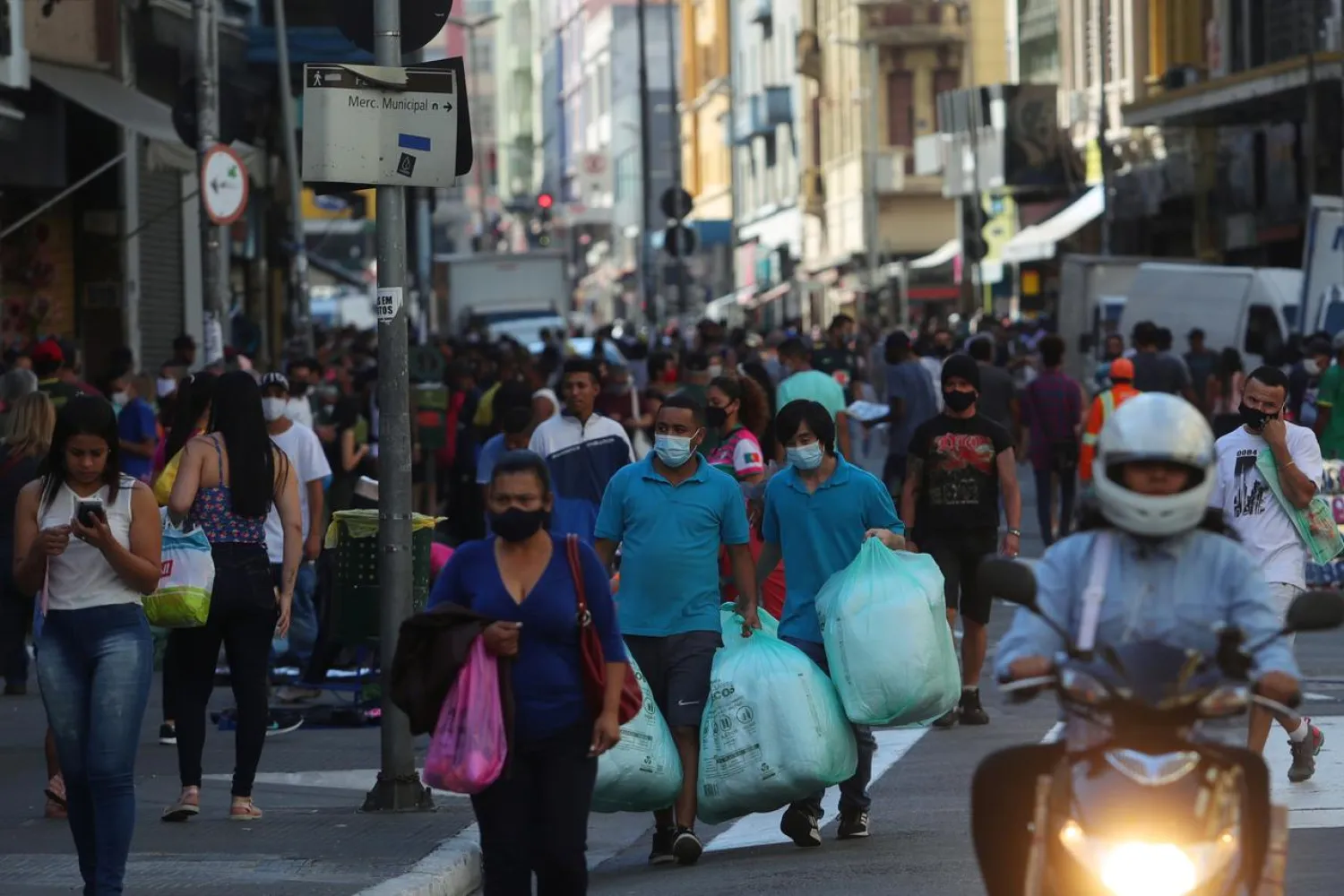 People walk with bags at a popular shopping street amid the coronavirus disease (COVID-19) outbreak, in Sao Paulo, Brazil, June 19, 2020. REUTERS/Amanda Perobelli
